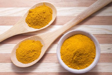 Ahşap arka plan (curcuma longa üzerine kaşıkla zerdeçal tozu)
