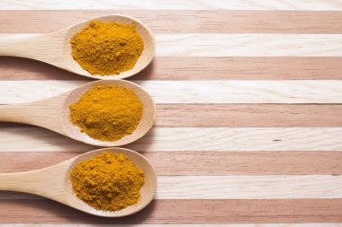 Ahşap arka plan (curcuma longa üzerine kaşıkla zerdeçal tozu)