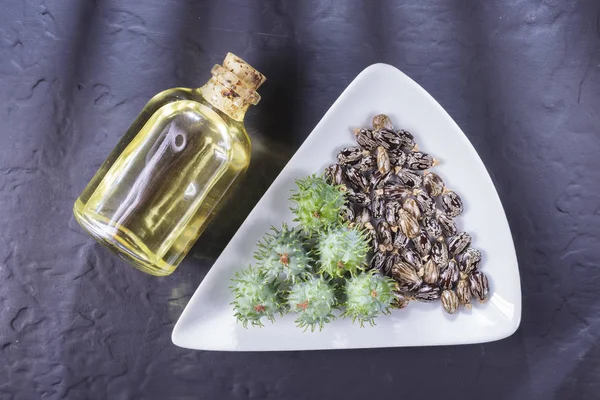 Frijoles y aceite de ricino sobre la mesa negra — Foto de Stock