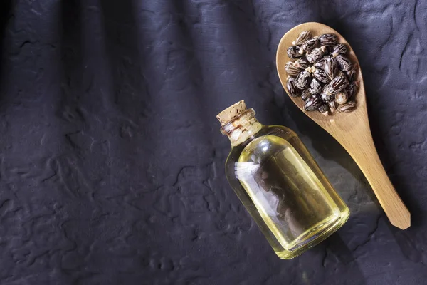 stock image beans and castor oil on the black table