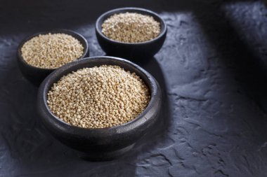 Quinoa Tahıl kaşık ve siyah arka plan üzerine kase
