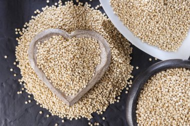 Quinoa Tahıl kaşık ve siyah arka plan üzerine kase