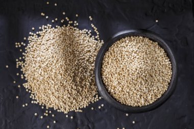 Quinoa Tahıl kaşık ve siyah arka plan üzerine kase