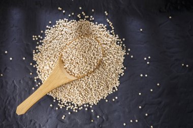 Quinoa Tahıl kaşık ve siyah arka plan üzerine kase