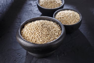 Quinoa Tahıl kaşık ve siyah arka plan üzerine kase