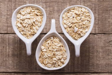 ahşap masa üzerinde beyaz kase yulaf gevreği