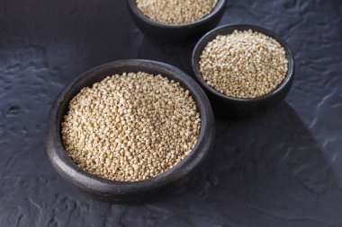 Quinoa Tahıl kaşık ve siyah arka plan üzerine kase