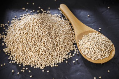 Quinoa Tahıl kaşık ve siyah arka plan üzerine kase