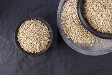 Quinoa Tahıl kaşık ve siyah arka plan üzerine kase