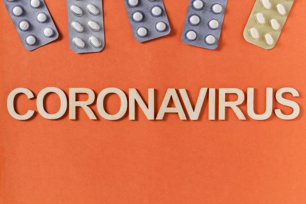 Coronavirus Wort Mit Holzbuchstaben Und Medikamententabletten Geschrieben Ansicht Von Oben — Stockfoto