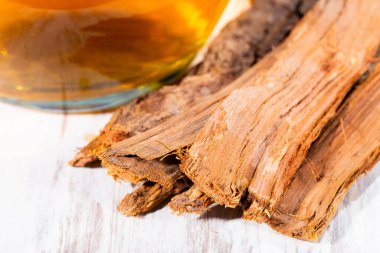 Ahşap arka planda kedi pençesi bitkisinin çay ve kabuğu, uncaria tomentosa