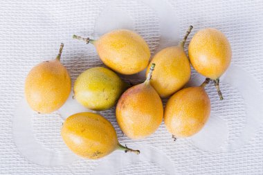 Nar meyvesi yığını, beyaz kumaş arka planda, yakın plan.