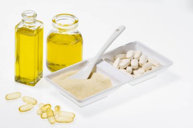 Sıvı kolajen, hidrolize edilmiş ve tabletlerde beyaz arkaplanda izole edilmiş, yakın plan görüntü