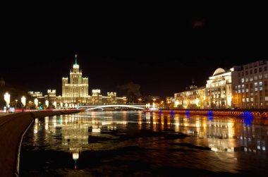 Kış akşamları Noel Aydınlatmaları Moskvoretskaya ve Raushskaya bentleri üzerinde. Yüksek katlı bina üzerinde Kotelnicheskaya dolgu, Moskova, Rusya Federasyonu