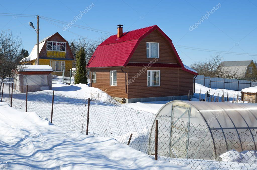 Wooden country house with a plot in winter