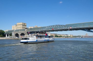 Pushkinsky (Andreevsky) yaya köprüsü ve Moskova nehri manzaralı bir eğlence teknesi. Moskova, Rusya