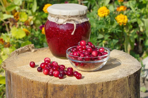 Cranberries mashed with sugar and fresh berries on a stump in the garden