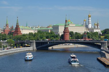 Moskova Kremlin manzarası, Büyük Taş Köprüsü ve güneşli bir yaz gününde eğlence tekneleri. Moskova, Rusya