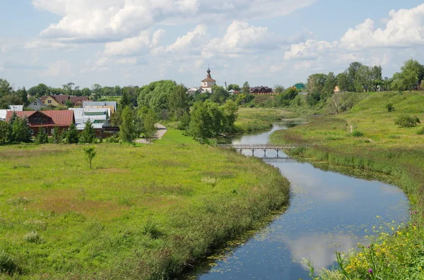 Güneşli bir yaz gününde Korovniki 'de Kamenka nehri ve Kosma ve Damian Kilisesi manzarası. Suzdal, Vladimir bölgesi. Rusya 'nın altın yüzüğü