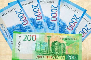 Rus parası. Tahta arka planda iki bin iki yüz rublelik banknotlar.