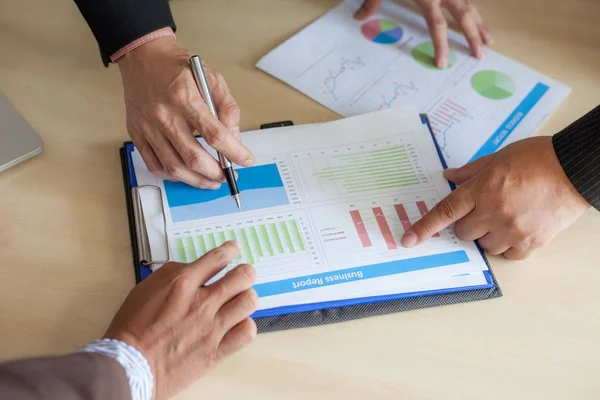 İş adamları grafikleri ve grafikleri tartışıyor.