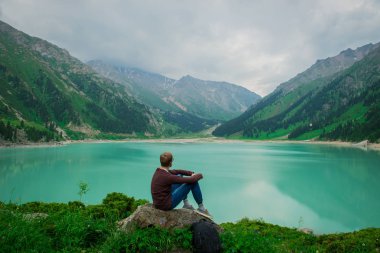 Büyük Almatı Gölü, Almatı, Kazakistan arka plan üzerinde bir adam
