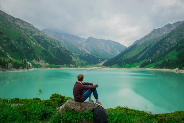 Büyük Almatı Gölü, Almatı, Kazakistan arka plan üzerinde bir adam