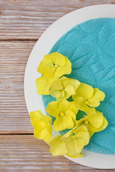 Essbare gelbe Hortensie auf blauem Moussekuchen. flache Lage — Stockfoto