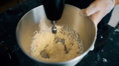 Yumurta sarısı ve metal bir kase şeker pudra hızlı mikseri karışımları.