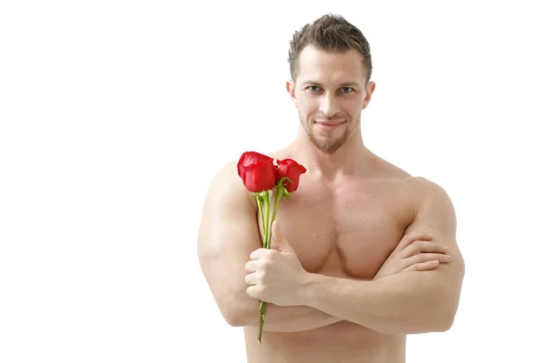 Seksi bir adam güzel bir ışık ile beyaz bir arka plan üzerinde bir gül verir. Beyaz arka plan üzerinde izole