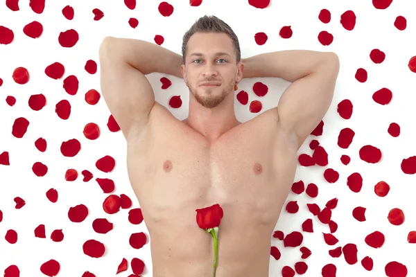 Wet nude muscular man with a rose