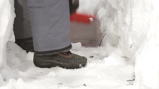 Man met schop reinigt de sneeuw van de weg na zware sneeuwval en lawines — Stockvideo