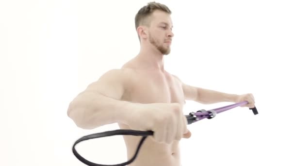 Colpo medio di un bodybuilder muscolare che fa esercizi di braccio con una fascia di resistenza su uno sfondo bianco — Video Stock