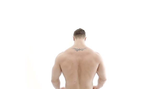 Middellange shot van een gespierde bodybuilder beoefening van de arm met een weerstand band op een witte achtergrond — Stockvideo