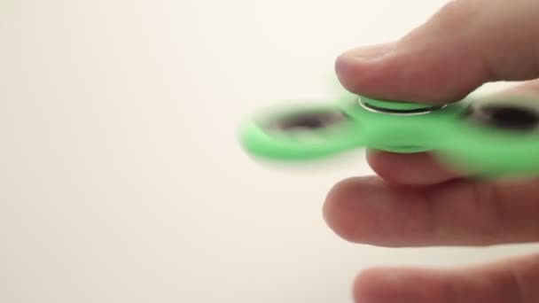 Gros plan de la toupie de fidget tournant sur la main masculine sur blanc 