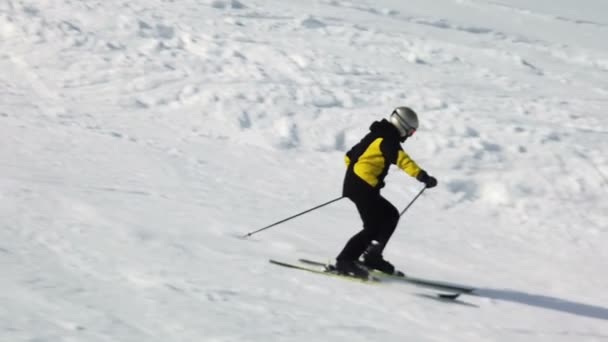 Genç yetişkin kayakçı soğuk kışta huzurlu ve mükemmel havanın tadını çıkarıyor. Kayak merkezindeki mükemmel hazırlanmış kayak pistinde tek başına kayak yapmak — Stok video