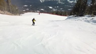 Young adult recreational skier enjoys idyllic perfect weather in cold winter. Skiing on perfectly groomed ski piste at ski resort