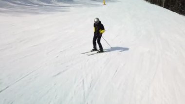 Young adult recreational skier enjoys idyllic perfect weather in cold winter. Skiing on perfectly groomed ski piste at ski resort