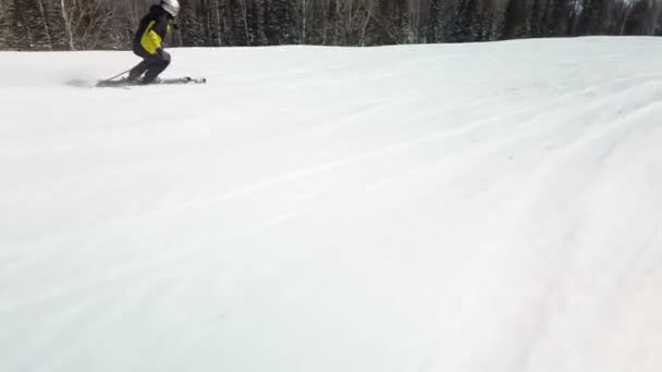 Young adult recreational skier enjoys idyllic perfect weather in cold winter. Skiing on perfectly groomed ski piste at ski resort — Stockvideo