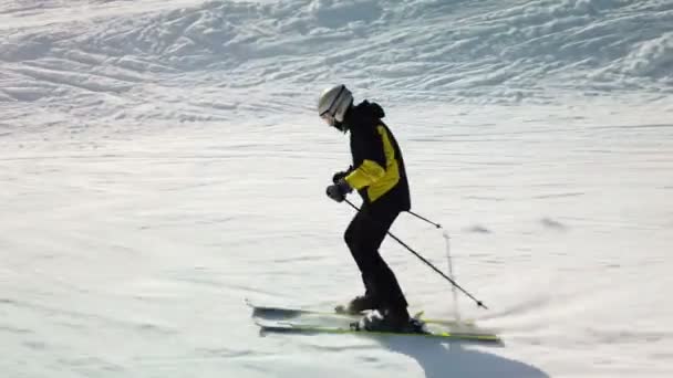 Young adult recreational skier enjoys idyllic perfect weather in cold winter. Skiing on perfectly groomed ski piste at ski resort — Stockvideo