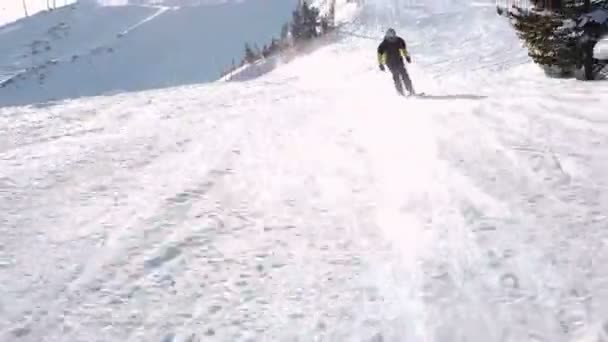 Jovem esquiador recreativo adulto goza de um clima idílico perfeito no inverno frio. Esqui sozinho em pista de esqui perfeitamente preparado em estância de esqui — Vídeo de Stock