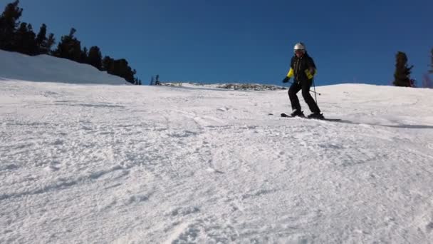 若い大人のレクリエーションスキーは寒い冬に牧歌的な完璧な天気を楽しんでいます。スキー場の完璧に圧雪されたスキー場で一人スキー — ストック動画