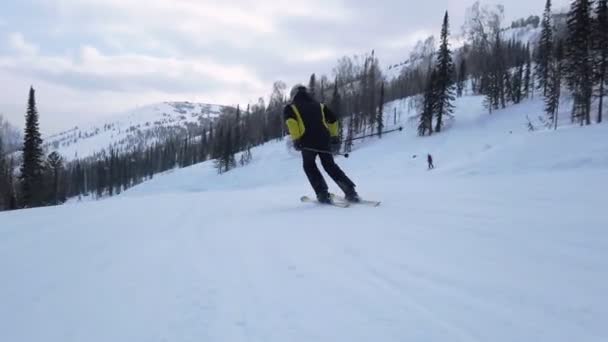 若い大人のレクリエーションスキーは寒い冬に牧歌的な完璧な天気を楽しんでいます。スキー場の完璧に圧雪されたスキー場で一人スキー — ストック動画