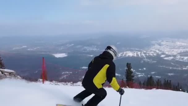 Young adult recreational skier enjoys idyllic perfect weather in cold winter. Skiing alone on perfectly groomed ski piste at ski resort. Located at the top of the mountain — Stock Video