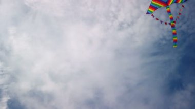 Mavi gökyüzünde uçan gökkuşağı uçurtması