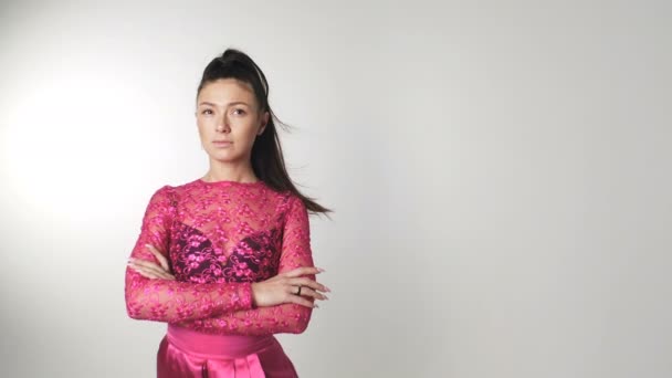 Hermosa mujer joven en vestido de color de flores sakura con el pelo revoloteando en el viento — Vídeos de Stock