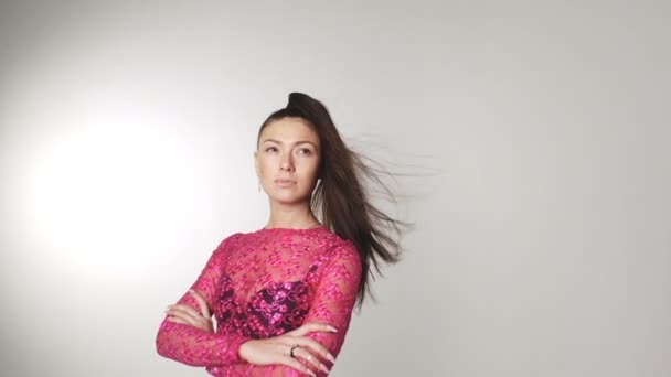 Hermosa mujer joven en vestido de color de flores sakura con el pelo revoloteando en el viento — Vídeos de Stock