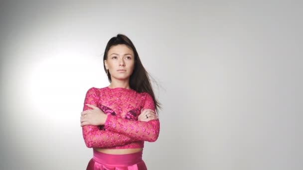 Hermosa mujer joven en vestido de color de flores sakura con el pelo revoloteando en el viento — Vídeos de Stock