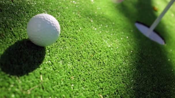 Detailní záběr golfista pomocí putter ponořit krátký putt do díry — Stock video