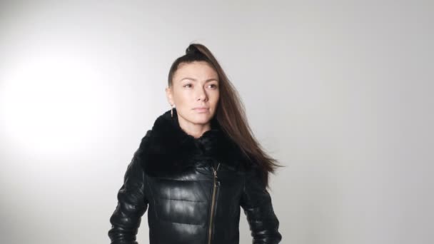 Modèle brune caucasienne en studio sur veste d'usure automne chaud concept proche. Mouvement lent dans le vent — Video